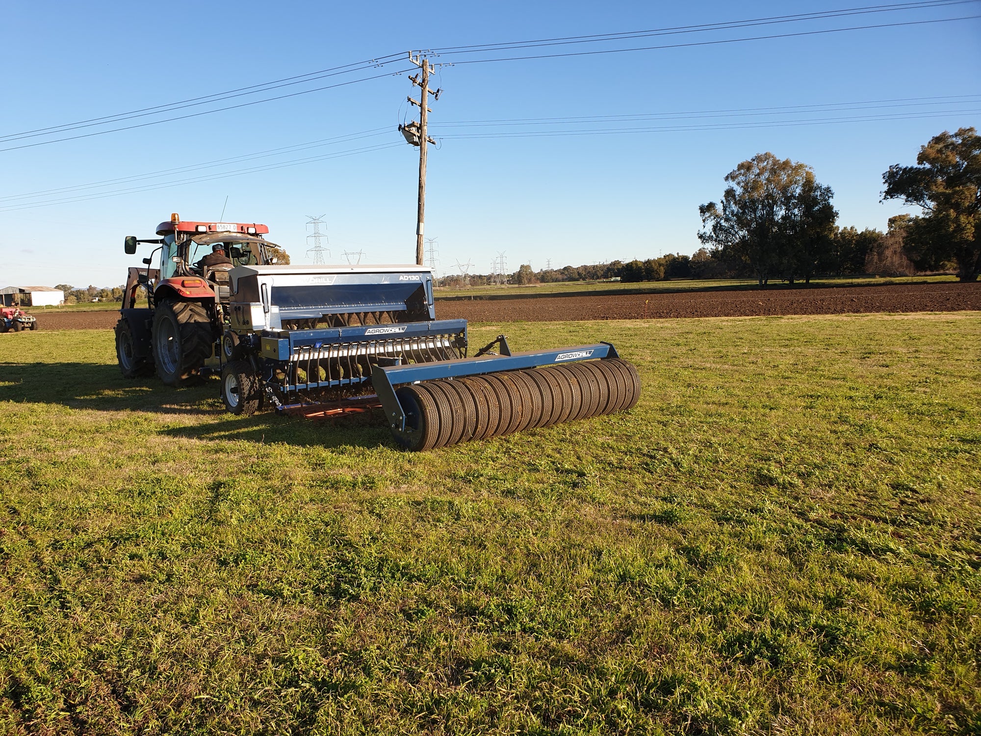 Agrowdrill seed drill trailing a rubber tyre soil roller