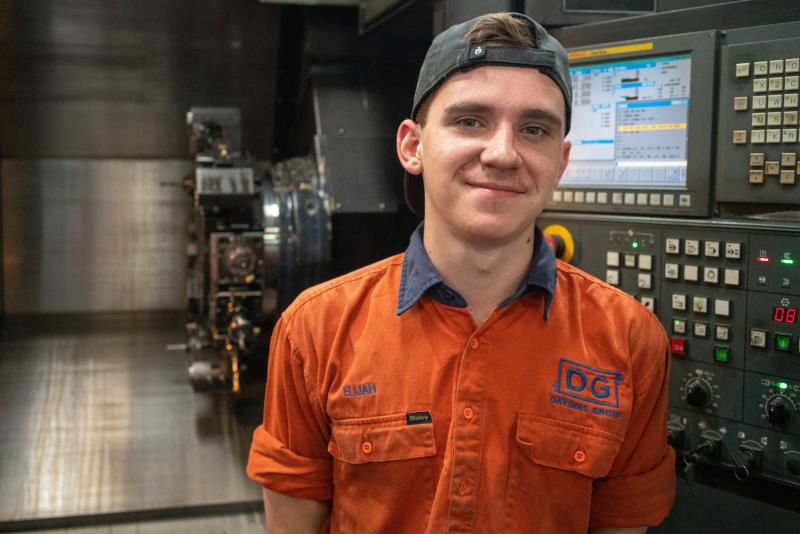 Workshop staff member in front of CNC machine