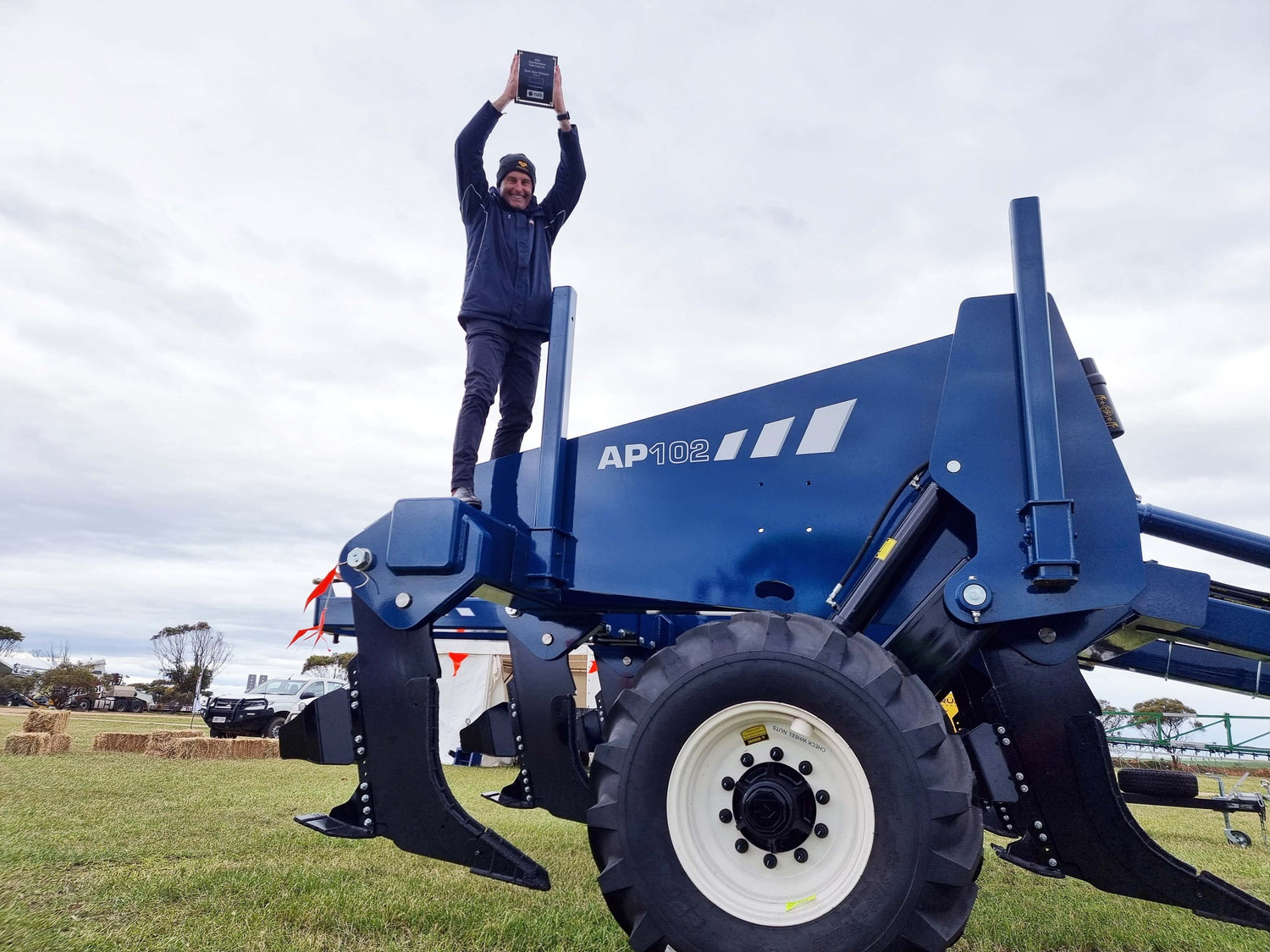 Agrowplow representative holding up an award on top of the AP102