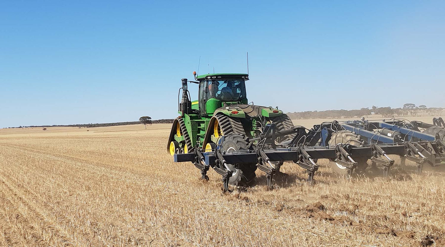 Agrowplow AP81 broadacre plough with shanks in soil towed behind John Deere tracked tractor